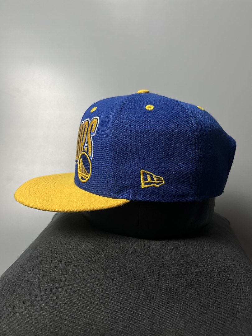 New Era Golden State Warriors 9FIFTY Snapback Cap (Category: Caps & Hats) located in Dagupan City. Submitted by loves2thrifth (Listing ID 1470368073, Image 2). Description: - Brand: New Era (Official NBA Merchandise) - Style: 9FIFTY Snapback Cap - Color: Royal blue crown with yellow flat brim and matching strap - Details: Embroidered team branding on front, interior taping and NBA tag intact - Size: Adjustable snap closure fits most - Condition: 
