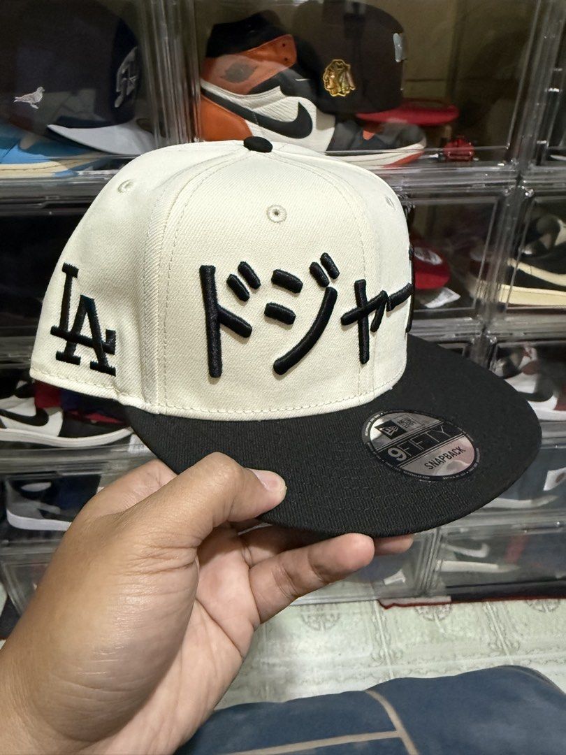 New Era LA Dodgers Japanese Script Snapback Hat (Category: Caps & Hats) located in Manila. Submitted by batoy8814895 (Listing ID 1470431886, Image 1). Description: - Brand: New Era 9FIFTY Snapback Cap - Colorway: Off-white crown with black visor and closure - Design: Rare Japanese script Dodgers embroidery on the front - Details: Classic LA logo on the side and original metallic 9FIFTY sticker on the flat brim - Condition: Clean structure with sh
