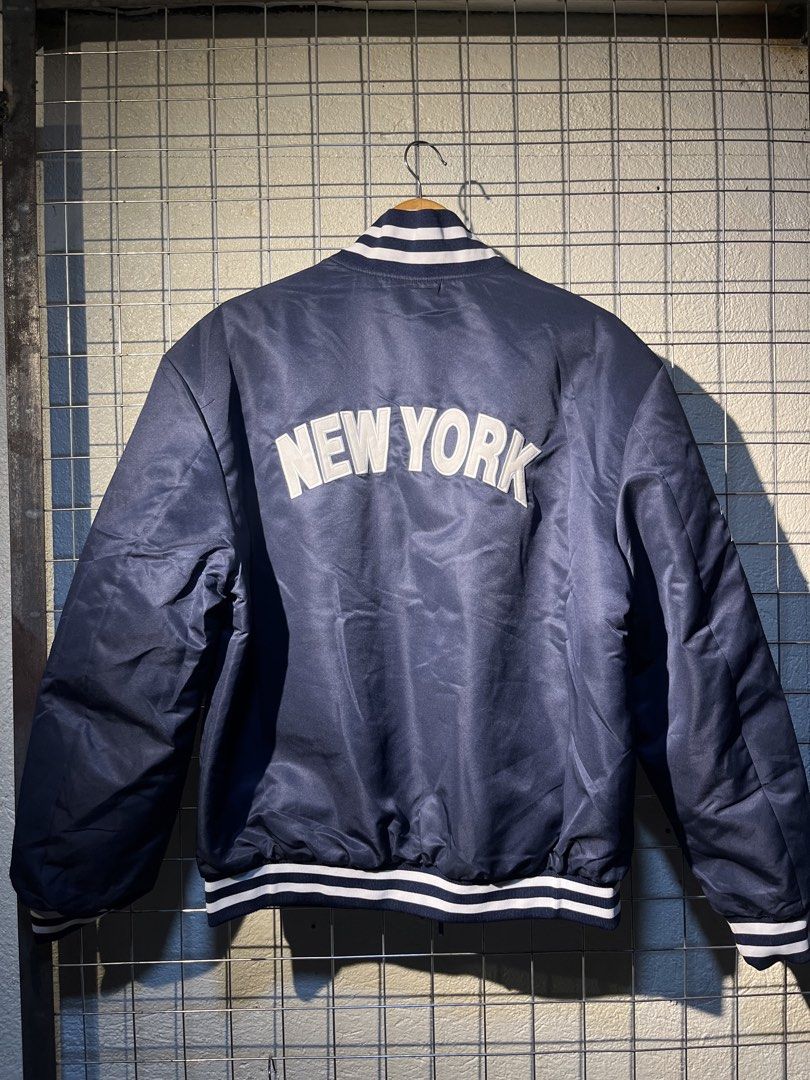 New Era New York Yankees Bomber Jacket (Category: Coats, Jackets and Outerwear) located in Manila. Submitted by roballenad66487 (Listing ID 1470386400, Image 3). Description: - Brand: New Era - Style: Bomber Jacket (Full Zip) - Color: Navy Blue - Team: New York Yankees (Chest embroidery & big back 'NEW YORK' lettering) - Details: American League patch on right sleeve, quilted inner lining, striped rib-knit collar, cuffs, and hem - Condition: Bran