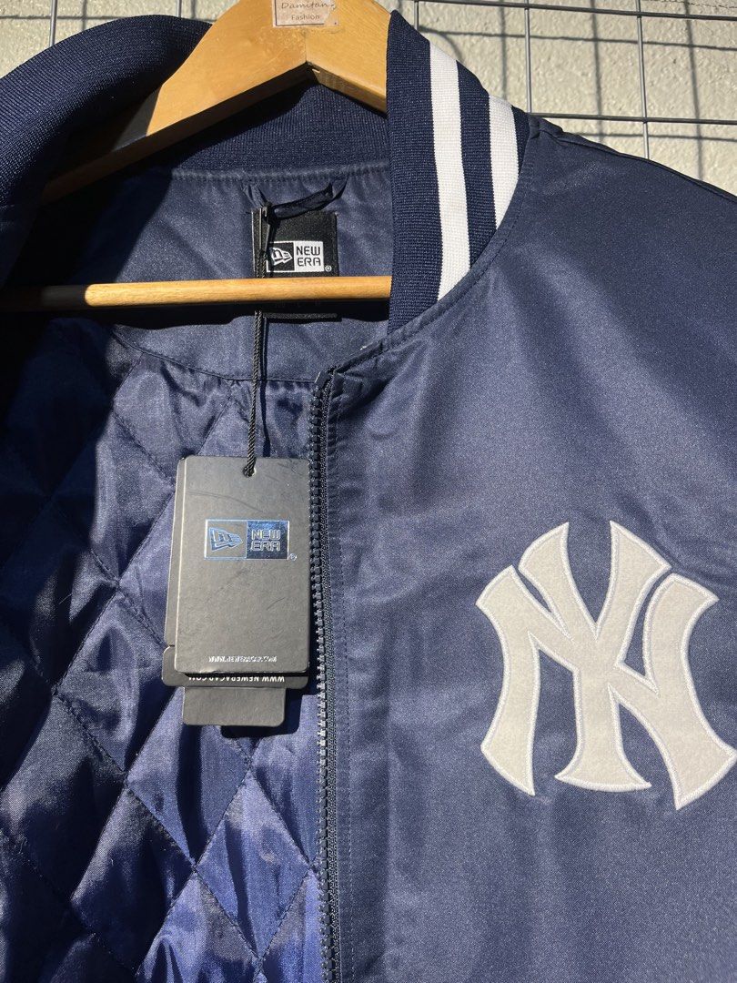 New Era New York Yankees Bomber Jacket (Category: Coats, Jackets and Outerwear) located in Manila. Submitted by roballenad66487 (Listing ID 1470386400, Image 2). Description: - Brand: New Era - Style: Bomber Jacket (Full Zip) - Color: Navy Blue - Team: New York Yankees (Chest embroidery & big back 'NEW YORK' lettering) - Details: American League patch on right sleeve, quilted inner lining, striped rib-knit collar, cuffs, and hem - Condition: Bran