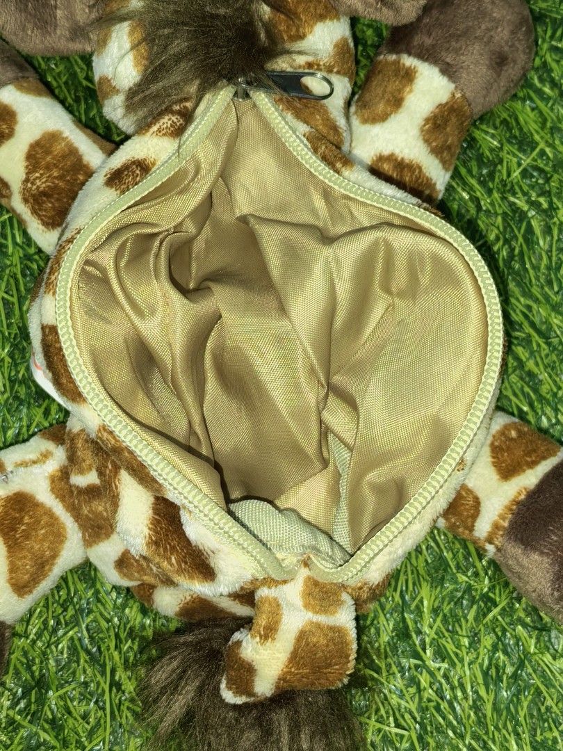 Nici Giraffe Plush Pencil Case (Category: Plushies & Soft Toys) located in Paranaque City. Submitted by furugiyafinds (Listing ID 1470455902, Image 3). Description: - Authentic Nici giraffe plush pencil case - Features cute brown spots and a fluffy mane - Secure zip closure along the front - Smooth golden-brown interior lining for pens and stationery - Soft and huggable plush material - Original Nici tag attached.