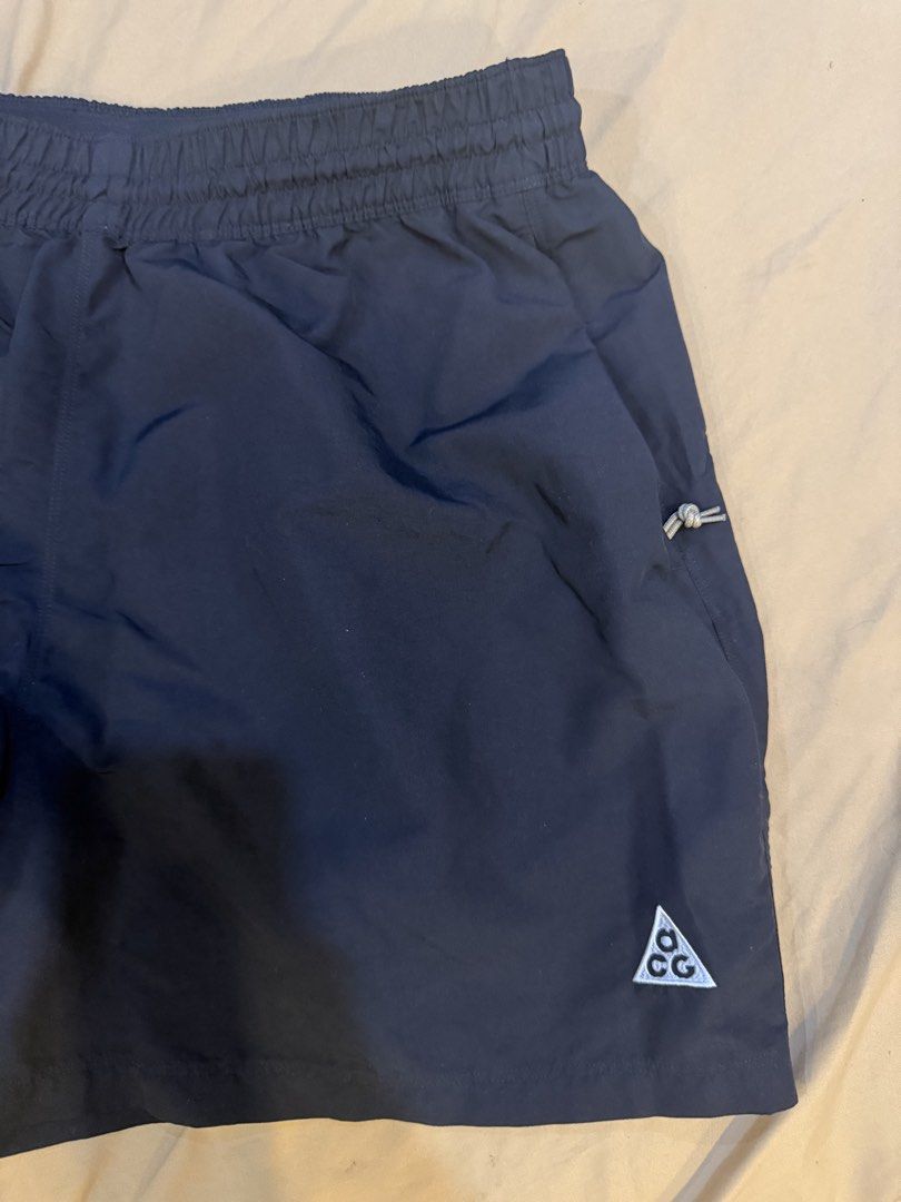 Nike ACG Black Shorts Size L (Category: Shorts) located in Caloocan City. Submitted by markarbuso66733 (Listing ID 1470481756, Image 3). Description: - Brand: Nike ACG - Color: Black - Size: L - Condition: Clean, excellent overall condition - Material: Lightweight fabric, perfect for hiking and casual wear - Features: Elastic waistband with drawstring, zippered side pockets with toggle cords, and front right metal loop - Branding: Classic embroid