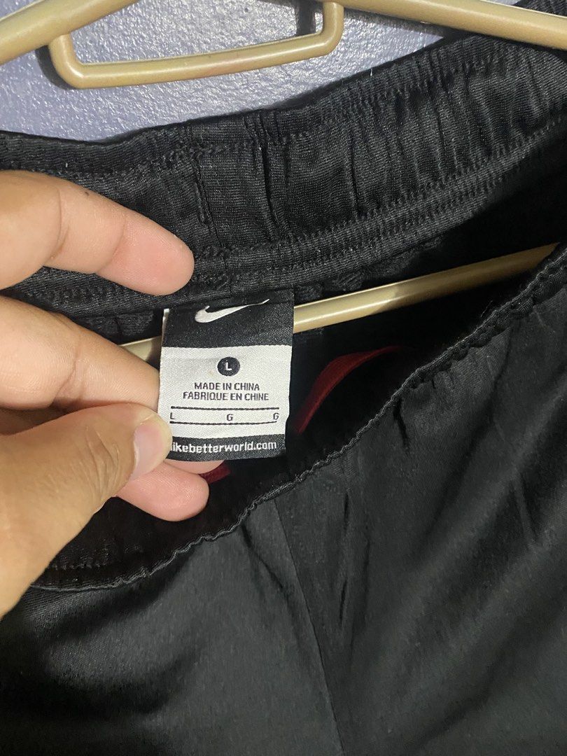 Nike Black and Red Track Pants Size L (Category: Joggers) located in Bangued. Submitted by koroysthrifts (Listing ID 1470495565, Image 3). Description: - Brand: Nike 28-32x35.5x9 - Color: Black with red side stripes - Logo: White logo hit on the hip - Size: Large - Condition: Clean, ready to wear - Features: Elastic waist for comfort, made in China - Ideal for: Workouts or lounging.