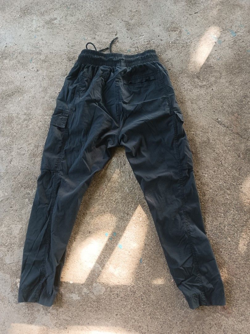 Nike Black Cargo Pants Size S (Category: Joggers) located in Manila. Submitted by anjo1 (Listing ID 1470556850, Image 2). Description: - Brand: Nike - Item: Cargo pants - Color: Black - Size: S - Material: Lightweight nylon (Made in Indonesia) - Waistband: Elastic with adjustable drawstring - Pockets: Multiple utility pockets with zippers - Branding: Classic white Nike patch - Style: Streetwear / Casual - Condition: Clean overall -26-34 x 35.5.