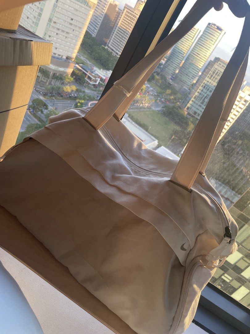 Nike Gym Bag (Category: Shoulder Bags) located in Muntinlupa City. Submitted by afs77 (Listing ID 1470440764, Image 1). Description: - Brand: Nike - Color: Off-white and cream - Features: Dual shoulder straps, secure zipper closure, interior zippered mesh pocket, and ventilation eyelets - Condition: Spacious capacity with visible wear on zipper pull tabs and some dirt marks on the fabric Location: Filinvest City/Alabang.
