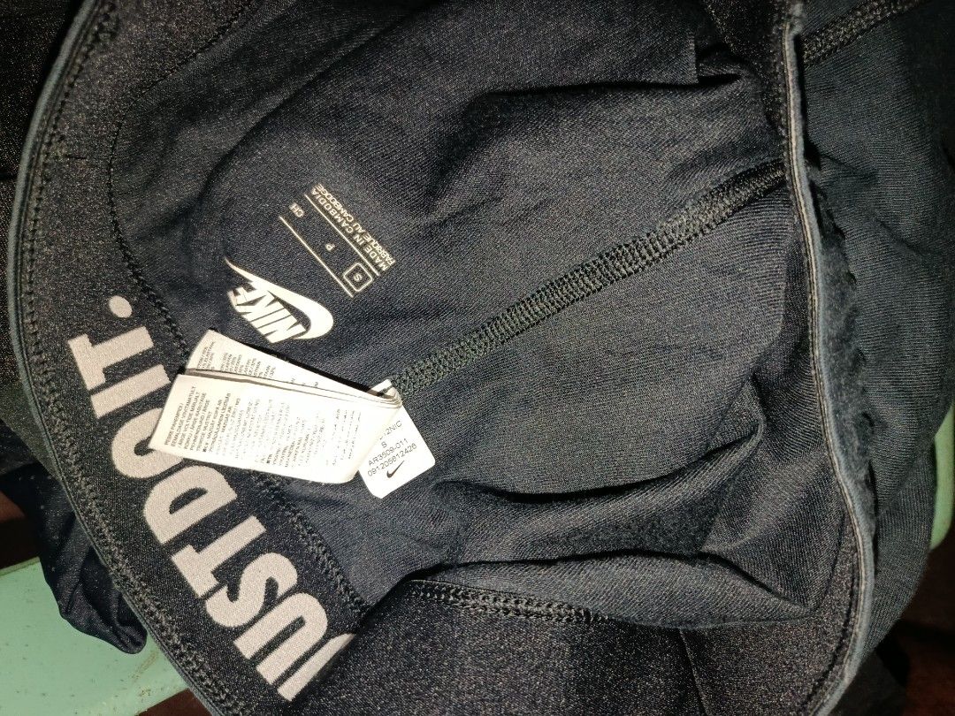 Nike Just Do It Leggings Black Size S (Category: Activewear) located in Nabunturan. Submitted by marmitoren42236 (Listing ID 1470395833, Image 2). Description: - Brand: Nike - Color: Black - Size: Small (S) - Made in Cambodia - Design: Large white swoosh graphic near the left ankle - Waistband: Wide elastic band with iconic 'Just Do It' text branding along the inside edge - Condition: Inner care label and size tag clearly intact.