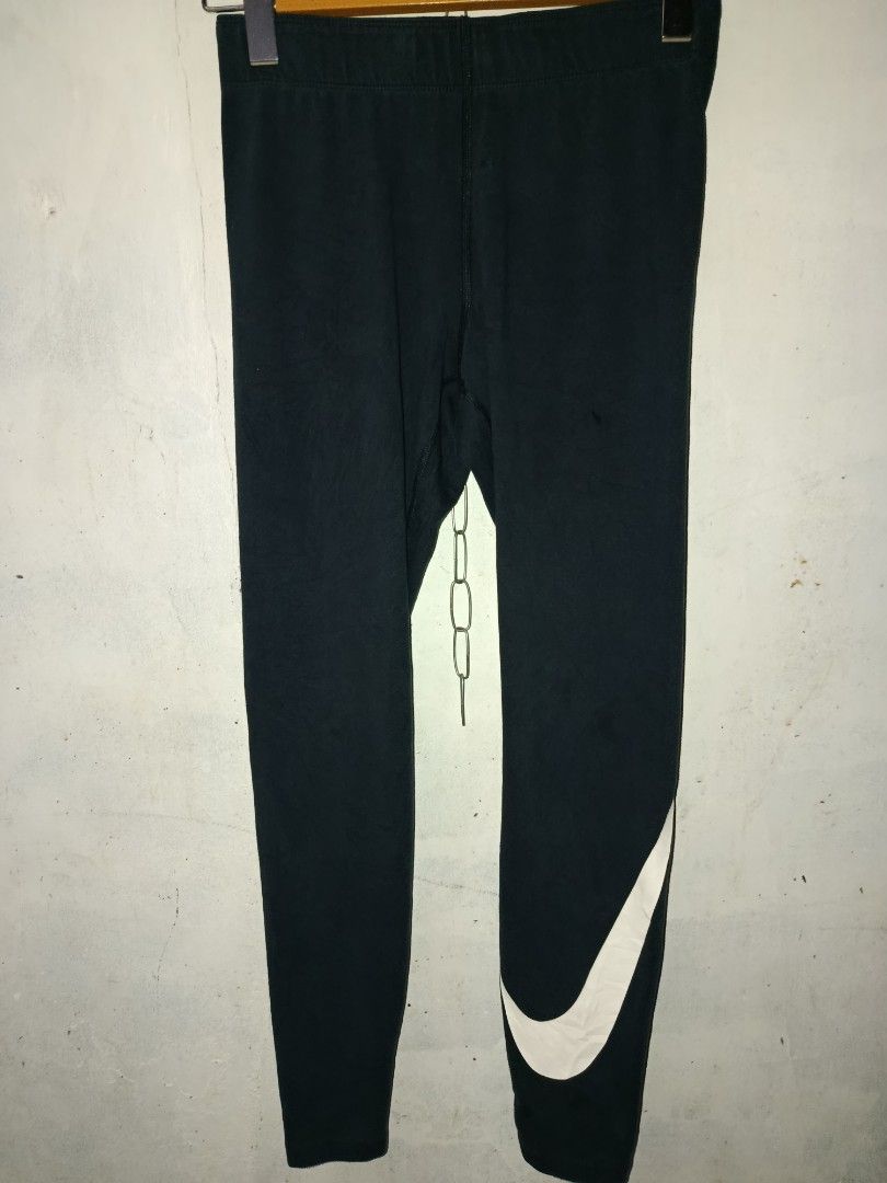 Nike Just Do It Leggings Black Size S (Category: Activewear) located in Nabunturan. Submitted by marmitoren42236 (Listing ID 1470395833, Image 3). Description: - Brand: Nike - Color: Black - Size: Small (S) - Made in Cambodia - Design: Large white swoosh graphic near the left ankle - Waistband: Wide elastic band with iconic 'Just Do It' text branding along the inside edge - Condition: Inner care label and size tag clearly intact.