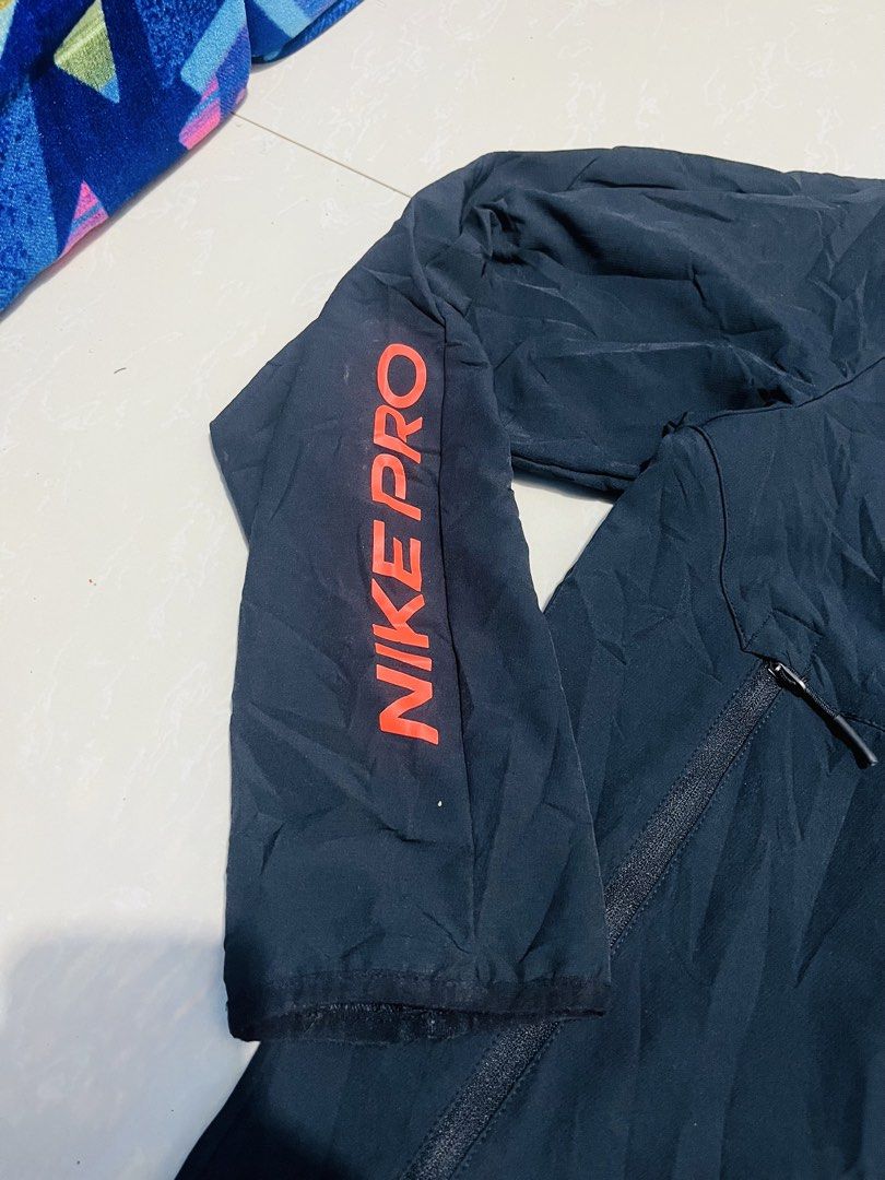 Nike Pro Black Half-Zip Packable Hoodie Jacket (Category: Coats, Jackets and Outerwear) located in Manila. Submitted by athan0800 (Listing ID 1470417212, Image 2). Description: - Brand: Nike Pro - Style: Half-zip hooded jacket with striking orange accents and sleeve branding - Size: XL (Standard fit) - Origin: Made in Vietnam - Features: Lightweight material, deep zipped front pockets, and built-in packable design for easy travel - Condition: Cle