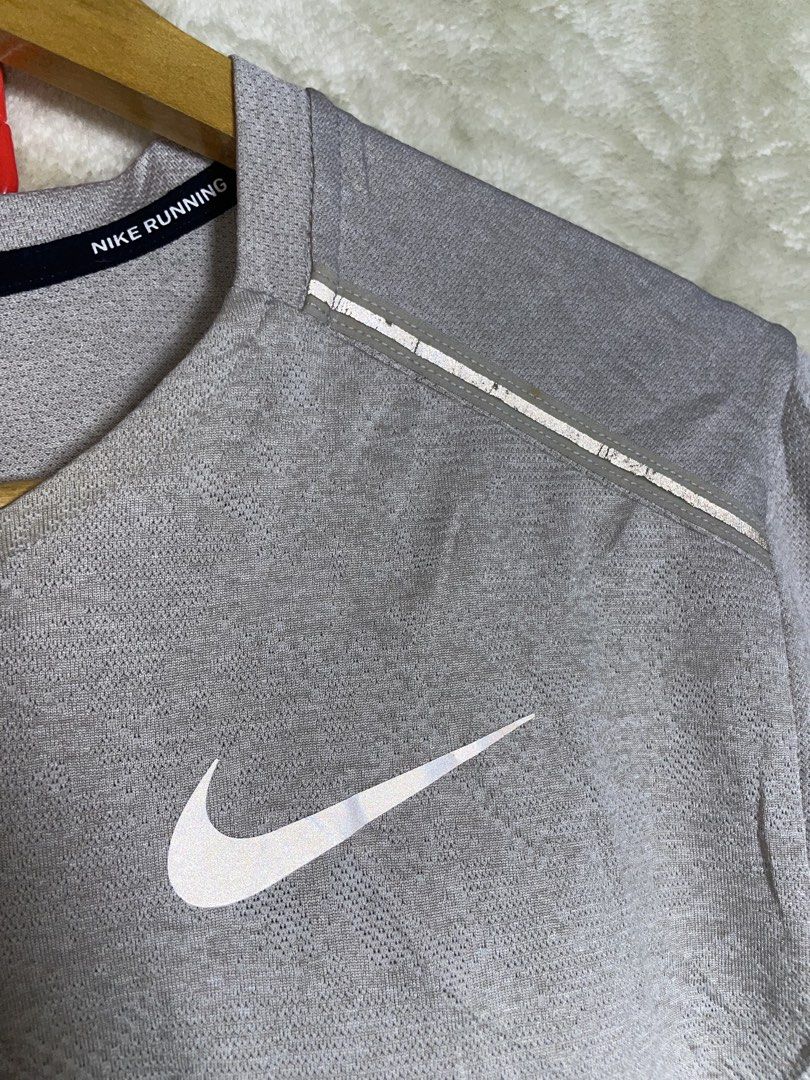 Nike Running Dri-FIT Shirt Grey Size M (Category: Activewear) located in Molave. Submitted by charlesthrifter (Listing ID 1470358459, Image 3). Description: - Brand: Nike - Item: Running Shirt - Color: Grey - Size: Medium - Technology: Dri-FIT moisture-wicking fabric - Safety: Reflective shoulder strips and chest swoosh for night visibility - Details: Interior Nike Running collar tape - Authenticity: Style code AJ7572-059 on inner tag - Condition