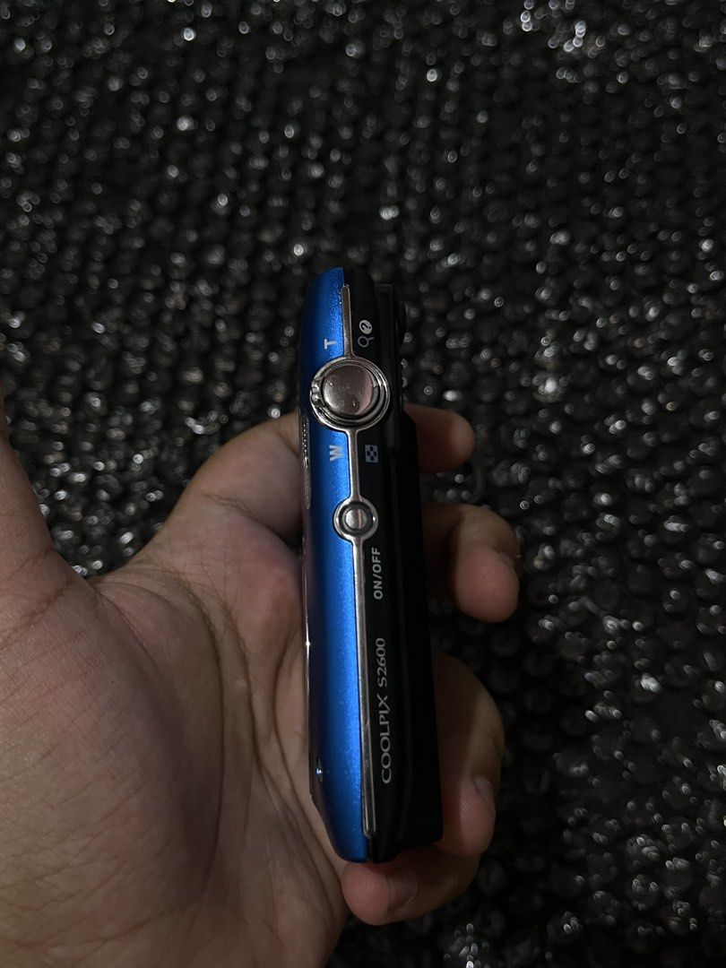 Nikon Coolpix S2600 (Category: Cameras) located in Manila. Submitted by r_zlxa (Listing ID 1470440710, Image 3). Description: - Model: Nikon Coolpix S2600 Compact Digital Camera - Color: Vibrant Blue - Lens: 5x optical zoom (4.6-23mm, f/3.2-6.5) - Features: Built-in flash, rear LCD screen with standard navigation buttons, and powers on via top button - Portability: Pocket-sized and lightweight, includes attached wrist strap - Ideal For: Daily sna
