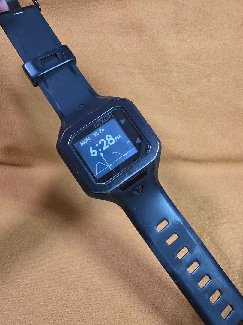 Nixon The Supertide Black Digital Watch (Category: Men's Watches) located in Rosales. Submitted by akumie30 (Listing ID 1470458560, Image 2). Description: - Brand: Nixon The Supertide - Color: Classic Black - Features: Digital display with tide graph data and stainless steel case back - Durability: Durable rubber strap with metal buckle and 100m water resistance - Condition: Light scuffs and wear from regular daily use - Functionality: Fully work