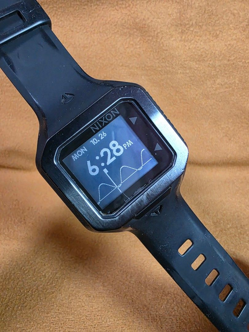 Nixon The Supertide Black Digital Watch (Category: Men's Watches) located in Rosales. Submitted by akumie30 (Listing ID 1470458560, Image 1). Description: - Brand: Nixon The Supertide - Color: Classic Black - Features: Digital display with tide graph data and stainless steel case back - Durability: Durable rubber strap with metal buckle and 100m water resistance - Condition: Light scuffs and wear from regular daily use - Functionality: Fully work
