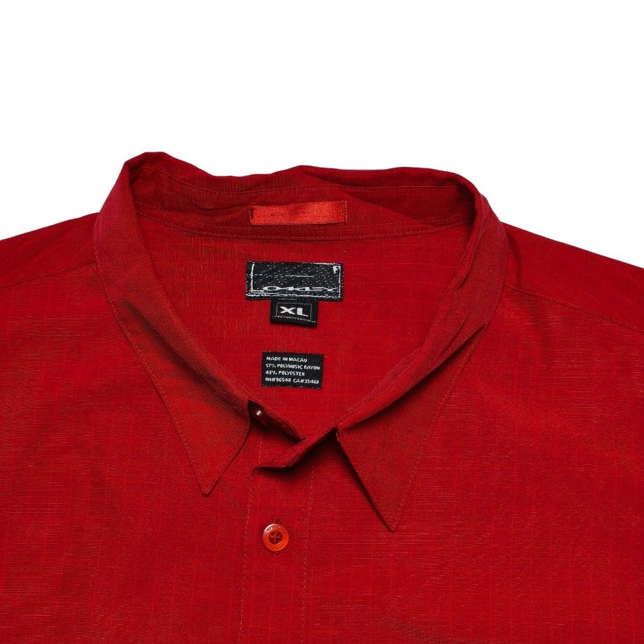 Oakley Red Short Sleeve Button Down Shirt Size XL (Category: Tshirts & Polo Shirts ) located in Meycauayan. Submitted by thrifting_gorilla (Listing ID 1470528100, Image 3). Description: Oakley Red Short Sleeve Button Down Shirt Size XL - Brand: Oakley - Style: Short sleeve button-down shirt with pointed collar - Color: Red with all-over grid texture pattern - Size: XL - Details: Left chest pocket with small metal Oakley logo icon, button front cl
