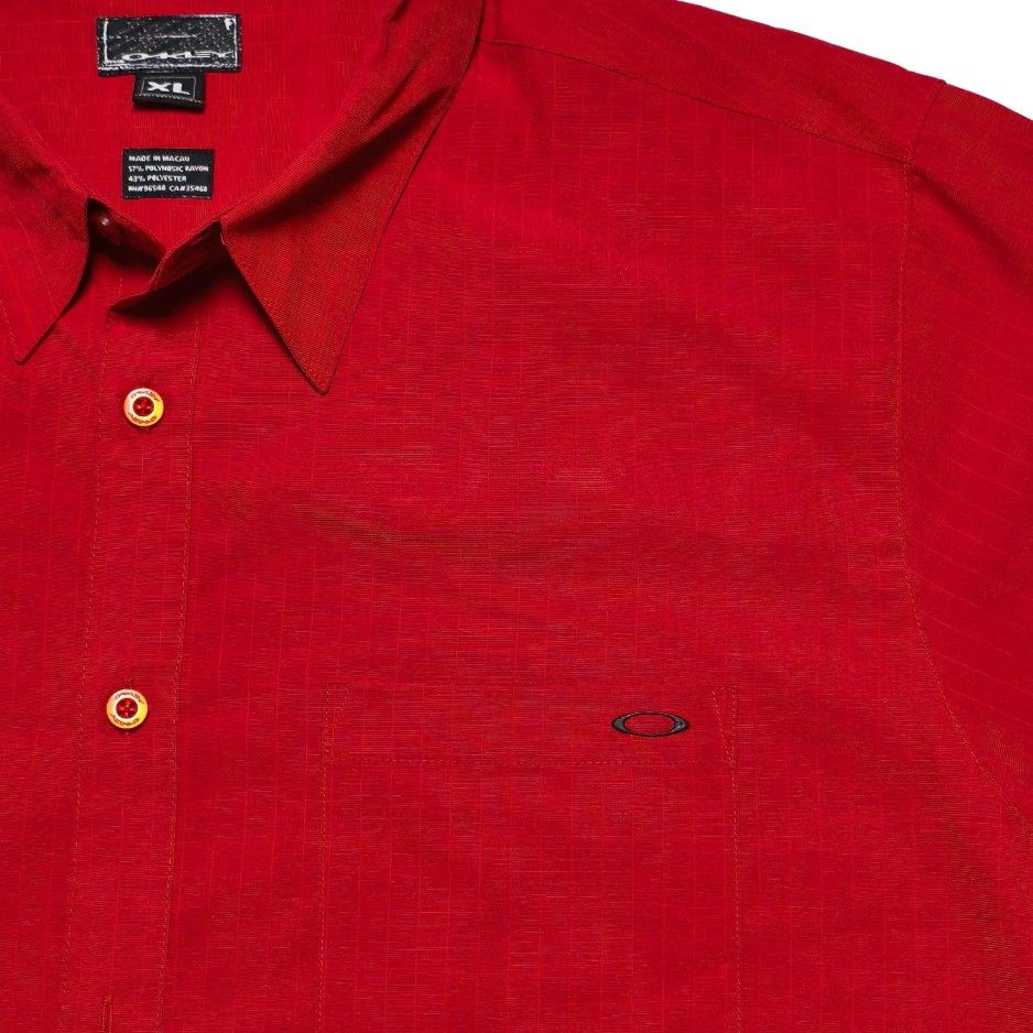 Oakley Red Short Sleeve Button Down Shirt Size XL (Category: Tshirts & Polo Shirts ) located in Meycauayan. Submitted by thrifting_gorilla (Listing ID 1470528100, Image 2). Description: Oakley Red Short Sleeve Button Down Shirt Size XL - Brand: Oakley - Style: Short sleeve button-down shirt with pointed collar - Color: Red with all-over grid texture pattern - Size: XL - Details: Left chest pocket with small metal Oakley logo icon, button front cl