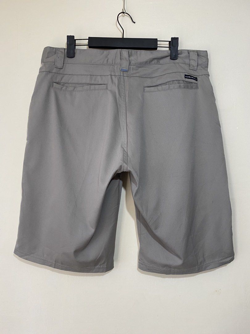 OAKLEY,Short (Category: Shorts) located in Cavite. Submitted by jc_thrift95 (Listing ID 1470418726, Image 2). Description: - a pair of Oakley Men’s gray performance or golf shorts featuring a flat-front design, belt loops, front and back pockets, and the iconic Oakley elliptical logo embroidered near the lower left hem. - Tag 36W - L- 22.5 inch - W- 18 inch - Color rate 8/10 (washable dirt) - See picture details for dimes..