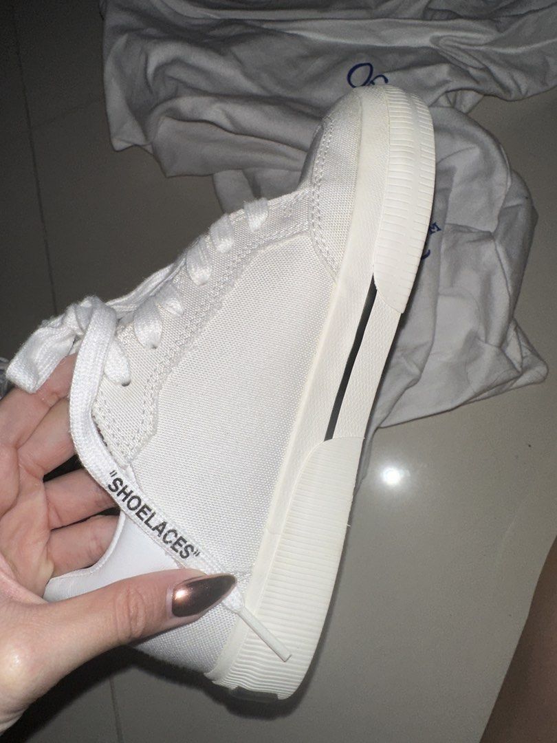 Off-White Low Top Canvas Sneakers (Category: Sneakers) located in Caloocan City. Submitted by ninarodriguez (Listing ID 1470488895, Image 2). Description: - Brand: Off-White - Style: White canvas low-top sneakers - Details: Black arrow embroidery, signature red zip-tie, 'SHOELACES' text on laces, and debossed outsole branding - Condition: Worn twice, soles show minor dirt from walking, can be cleaned - Inclusion: Comes with 2 white dust bag - Bou