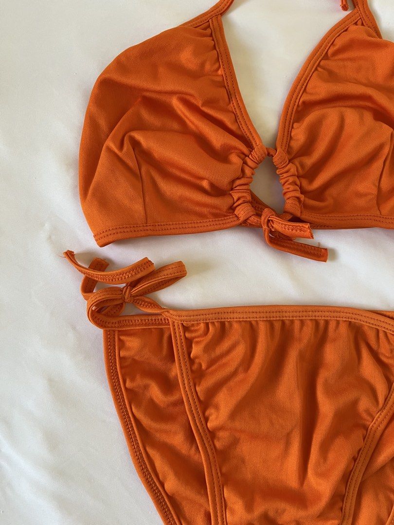 Orange Halter Bikini Set with Side Ties (Category: Bikinis & Swimsuits) located in Taytay. Submitted by prelovedbyblaire (Listing ID 1470384427, Image 2). Description: Bought in Bali - Color: Vibrant orange - Style: Two-piece swimsuit - Top: Halter neck with gathered center ring detail - Bottoms: Matching with adjustable side tie closures - Material: Smooth, stretchy fabric - Perfect for: Summer trips, pool parties, and beach days.