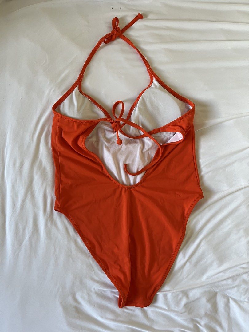 Orange halter one-piece swimsuit (Category: Bikinis & Swimsuits) located in Taytay. Submitted by prelovedbyblaire (Listing ID 1470385071, Image 2). Description: - Color: Bright orange - Style: Halter neck one-piece with adjustable tie closures - Design: Deep V-neckline and sexy open back - Comfort: Built-in cup padding for extra support - Lining: Fully lined with clean white fabric - Condition: Flawless, clean with no stains or damage.