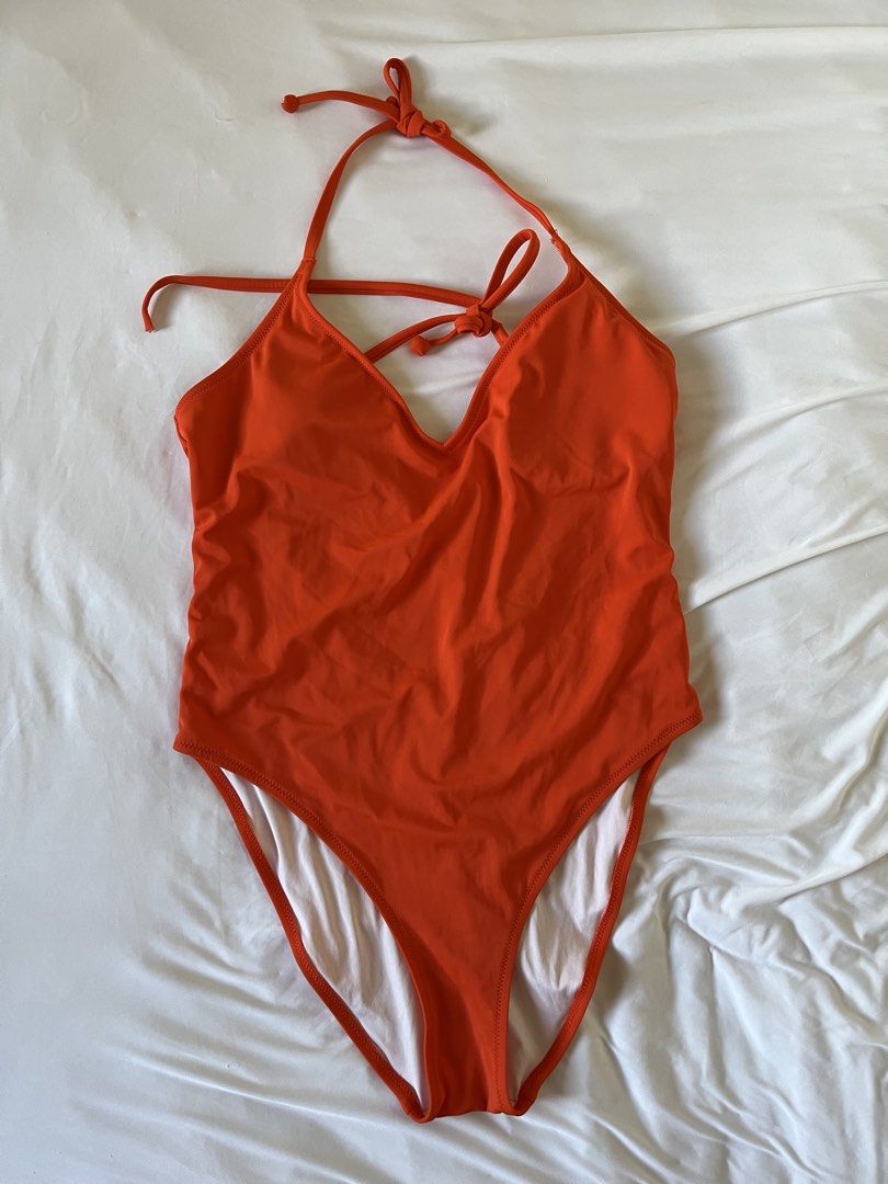 Orange halter one-piece swimsuit (Category: Bikinis & Swimsuits) located in Taytay. Submitted by prelovedbyblaire (Listing ID 1470385071, Image 1). Description: - Color: Bright orange - Style: Halter neck one-piece with adjustable tie closures - Design: Deep V-neckline and sexy open back - Comfort: Built-in cup padding for extra support - Lining: Fully lined with clean white fabric - Condition: Flawless, clean with no stains or damage.