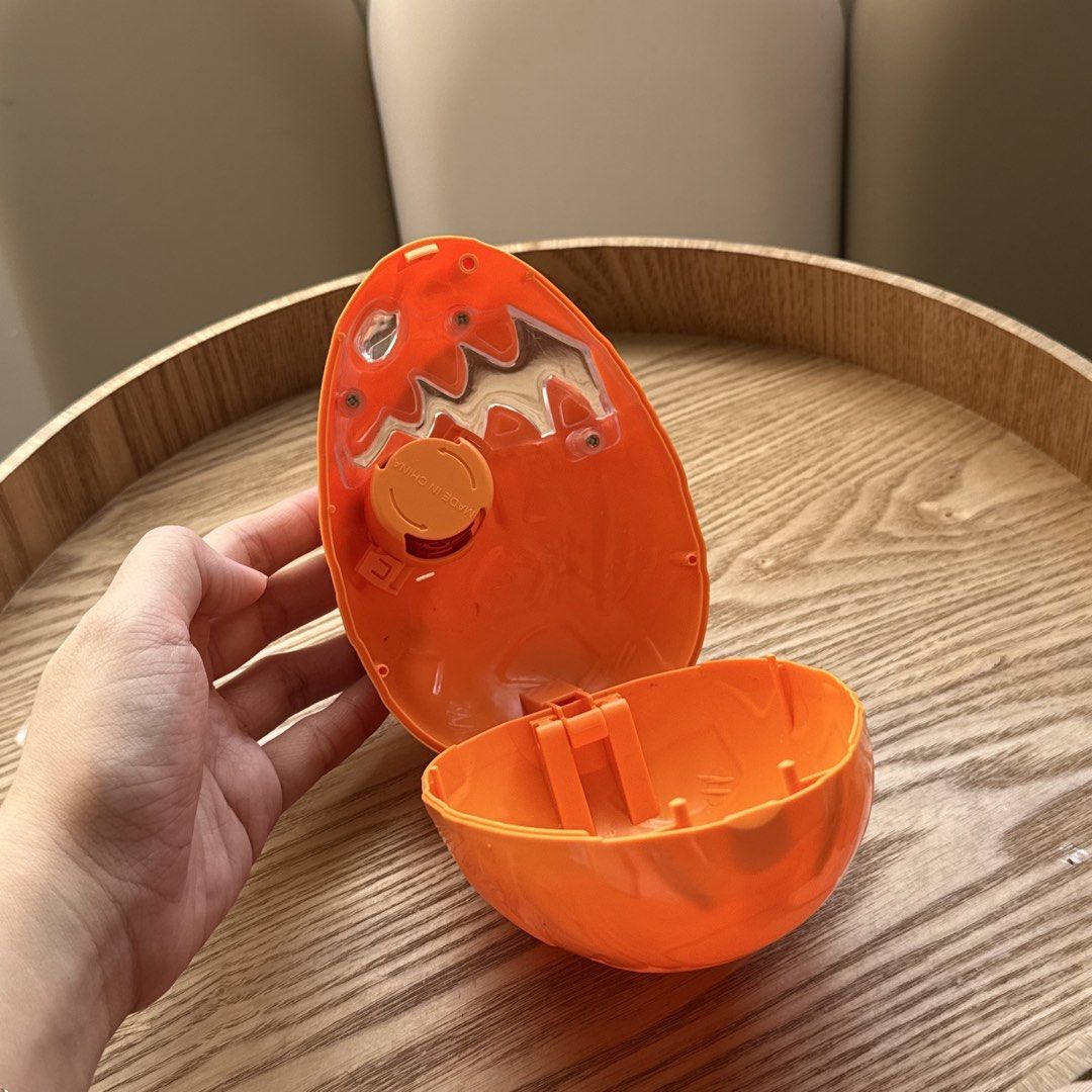 Orange Monster Dinosaur Egg Toy Container (Category: Kids Toys) located in Marikina City. Submitted by lovegoeson (Listing ID 1470535245, Image 2). Description: - Bright orange plastic monster egg container - Textured outer shell with fun molded teeth and eye details - Hinged design opens up to store small items, toys, or treats - Convenient round twist cover on the inside lid - Clean inside and out, ready for play.