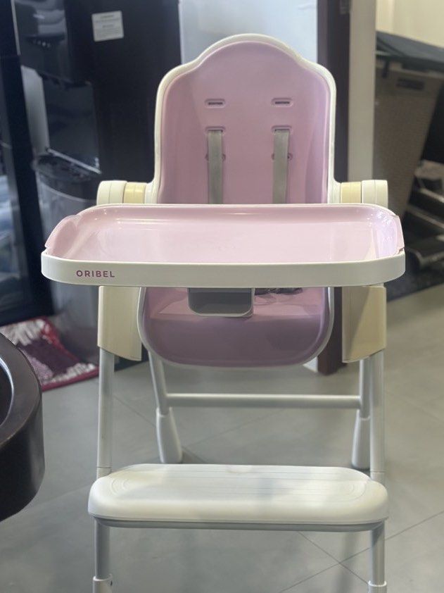 Oribel Cocoon High Chair Pink (Category: Baby High Chairs) located in Cavite. Submitted by prelovedbymaeve (Listing ID 1470554690, Image 1). Description: - Brand: Oribel High Chair - Color: Pink and White - Features: Adjustable height, recline positions, removable tray, and footrest - Functionality: Frame and wheels work normally, great space saver - Condition Notes: Straps show some discoloration and footrest has a small stain.