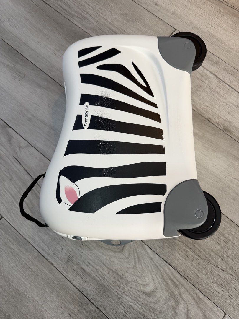Original Samsonite Zebra Kids Ride-On Suitcase (Category: Luggage) located in Quezon City. Submitted by legitseller08 (Listing ID 1470433745, Image 2). Description: - Authentic Samsonite kids ride-on luggage in a fun white and black zebra print with cute pink ears - Features top carry handles, smooth-rolling wheels, and secure closure clips - Condition: Clean surfaces with minor scuffs near the zebra print from handling - Fully functional with sm