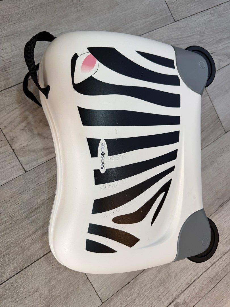 Original Samsonite Zebra Kids Ride-On Suitcase (Category: Luggage) located in Quezon City. Submitted by legitseller08 (Listing ID 1470433745, Image 3). Description: - Authentic Samsonite kids ride-on luggage in a fun white and black zebra print with cute pink ears - Features top carry handles, smooth-rolling wheels, and secure closure clips - Condition: Clean surfaces with minor scuffs near the zebra print from handling - Fully functional with sm