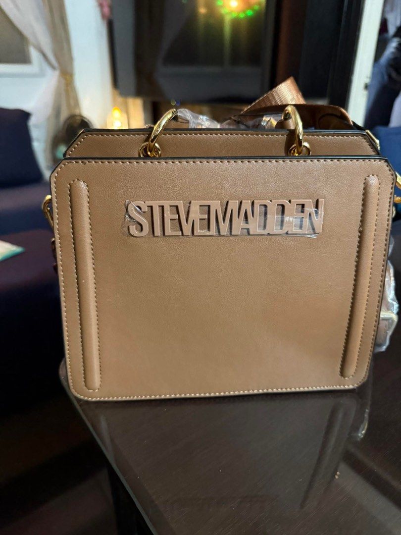 Original Steve Madden Brown Crossbody Bag (Category: Cross-body Bags) located in Manila. Submitted by _itsmimi (Listing ID 1470487482, Image 1). Description: - Brand: Steve Madden - Color: Brown - Design: Structured box design with large raised front logo - Hardware: Gold-tone rings - Condition: Brand new, pristine with zero scuffs, protective plastic film still wrapped around branding and handles - Strap: Includes a long, adjustable strap.