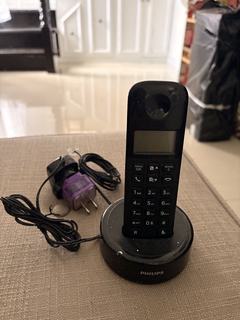 Philips D130 Cordless Telephone with Charging Base (Category: Early Generation Mobile Phones) located in Manila. Submitted by ch0431 (Listing ID 1470372888, Image 2). Description: Philips D130 cordless landline phone in black. Includes handset, charging dock, power adapter, and phone cable. Standard keypad with digital display screen. Battery compartment cover intact on the back. Base has some paint splatters on top surface. Fully functional setu