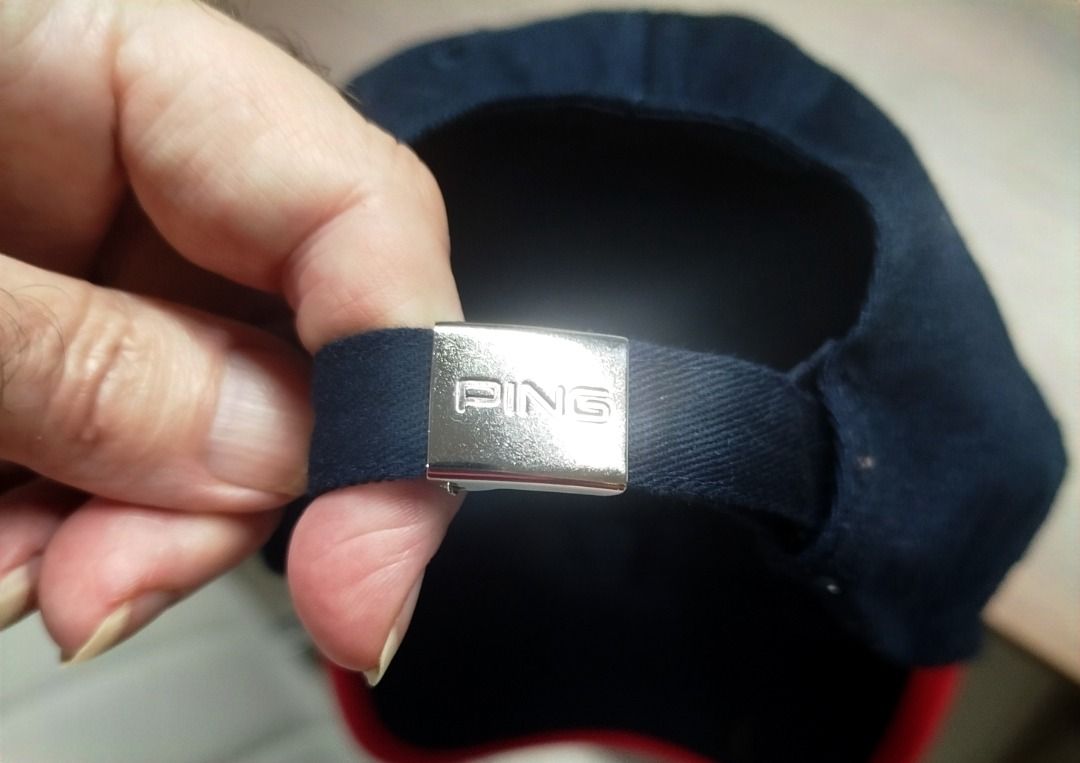 Ping Golf Cap Navy Blue Red White Adjustable (Category: Caps & Hats) located in Caloocan City. Submitted by safebear_4bdc70 (Listing ID 1470453390, Image 2). Description: Navy blue Ping cap with embroidered white and red logo on the front. Brim has red trim with a white accent piping line. Adjustable metal buckle strap at the back featuring the Ping logo engraved on the clasp. Red top button..