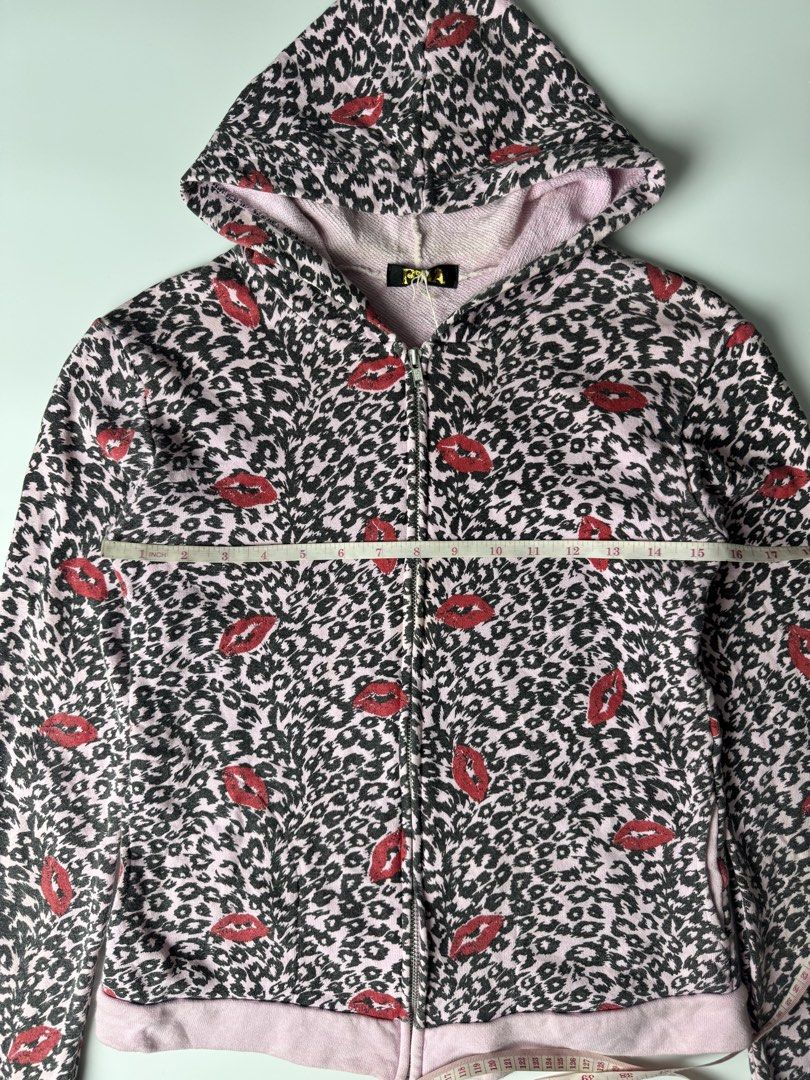 Pink Leopard Lips Zip-Up Hoodie (Category: Coats, Jackets and Outerwear) located in Manila. Submitted by babygirly2k (Listing ID 1470403596, Image 2). Description: - Style: Pink full-zip hoodie with black leopard print and red lips - Comfort: Soft, cozy interior lining with attached hood - Features: Convenient front pockets, ribbed pink cuffs and hem - Measurements: 17" pit-to-pit, 24" length, 25" sleeve length - Condition: Excellent find, perfec