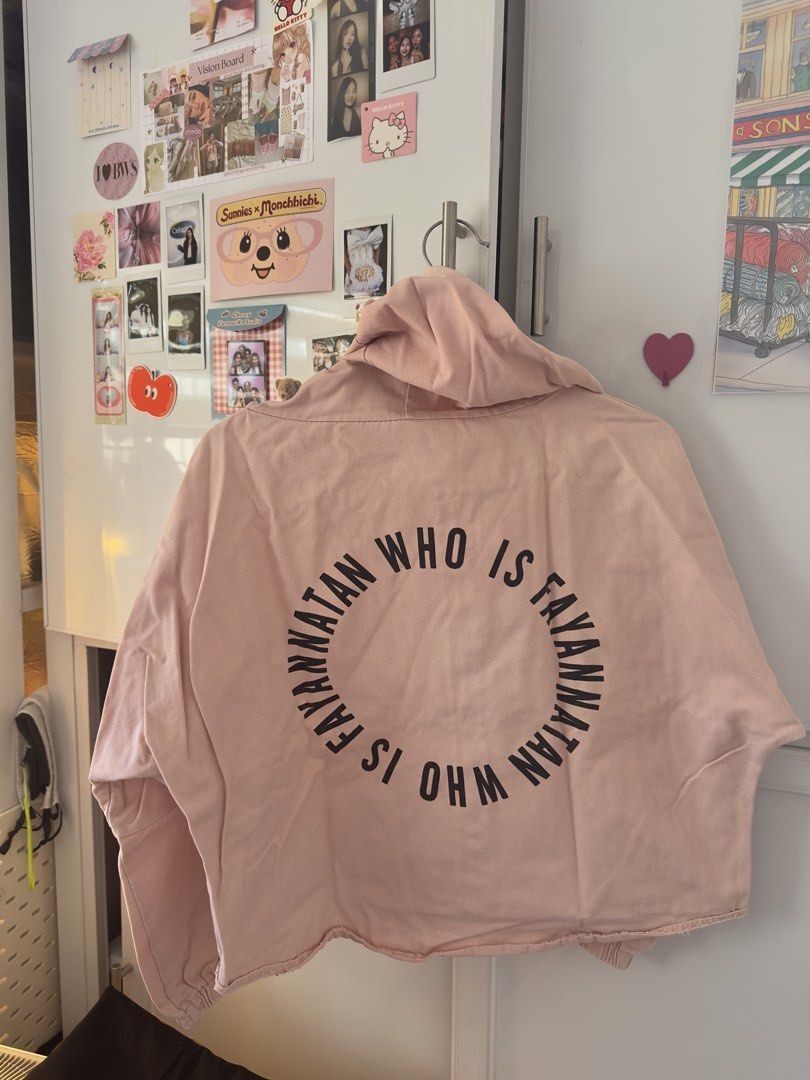 Pink zip-up hoodie with back text print (Category: Coats, Jackets and Outerwear) located in Manila. Submitted by preloved-bycath (Listing ID 1470355544, Image 2). Description: - Color: Light pink - Fit: Trendy cropped fit with drop shoulder sleeves - Details: White drawstring cords with metal tips, front kangaroo pocket, and raw edge hem - Design: Eye-catching 'Who Is Fayannatan' big text print in a circle layout on the back - Condition: Brand ne