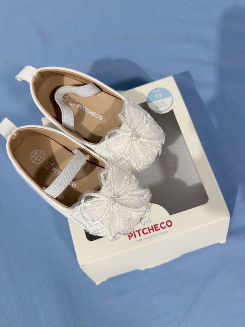 Pitcheco White Pre-Walker Shoes Size 13 9-12 Months (Category: Babies & Kids Fashion) located in Tanza. Submitted by calmwind_2a9316 (Listing ID 1470512189, Image 1). Description: - Brand: Pitcheco - Color: White - Size: 13 (Fits babies 9 to 12 months) - Design: Delicate mesh bow with a small pearl detail in the center - Fit: Elastic strap across the top for a secure and comfortable fit - Condition: Like new with original box and retail price tag