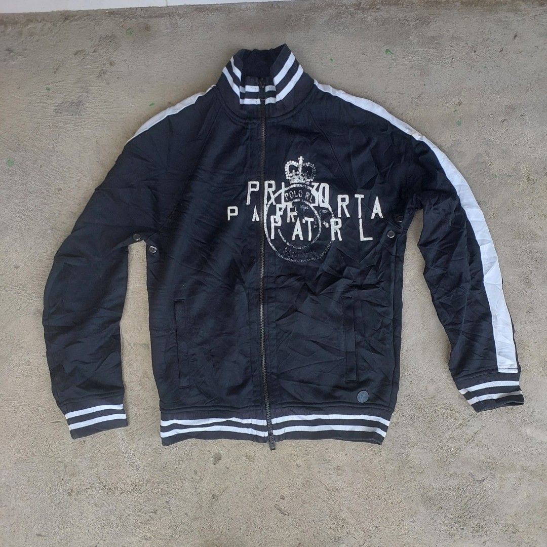 Polo Ralph Lauren Black Track Jacket Size M (Category: Coats, Jackets and Outerwear) located in Caloocan City. Submitted by shikiibun (Listing ID 1470490294, Image 1). Description: - Brand: Polo Ralph Lauren - Color: Black with white side stripes and details - Size: M - Material: 74% nylon, 26% cotton blend - Design: Full zip closure, ribbed collar, cuffs, and hem - Features: Two front pockets and a large crown graphic print on the front.