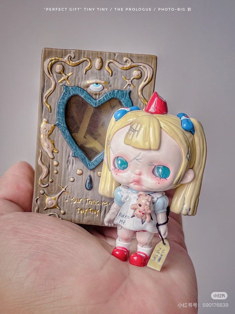 POP MART TINY TINY Perfect Gift Secret (Category: Designer & Blind Box Toys) located in Manila. Submitted by lebronlabubu (Listing ID 1470374767, Image 2). Description: - Series: Pop Mart Tiny Tiny Series - Character/Item: Perfect Gift figure - Design Details: Blonde pigtails, blue eyes, holding a teddy bear in a 'Broken Me' dress - Included Accessory: Matching decorated book with a heart window - Packaging: Original box included - Condition: Bra