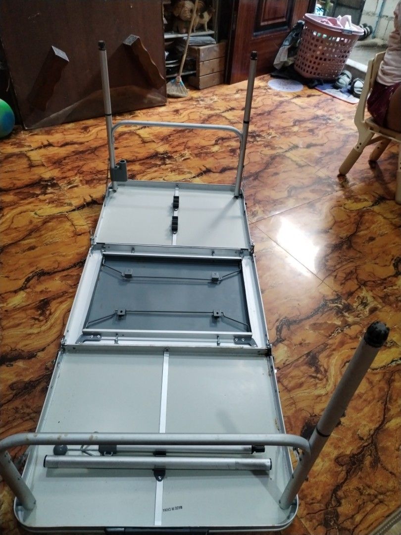 Portable Foldable Aluminum Camping Table (Category: Hiking & Camping) located in Caloocan City. Submitted by rowely_jpn (Listing ID 1470552366, Image 2). Description: Aluminum camping table that folds in half for easy storage and transport. Silver metal top with a grey middle section. Sturdy folding legs with adjustable height settings. Built-in handle for carrying when folded up. Handy for camping trips, outdoor picnics, backyard barbecues, or e