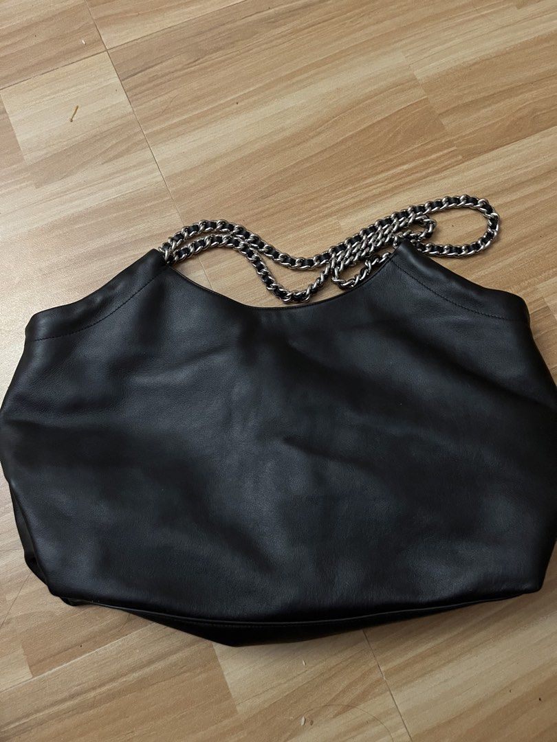 Prada Black Leather Chain Tote Bag (Category: Luxury Bags & Wallets) located in Victorias. Submitted by lan1877 (Listing ID 1470476161, Image 2). Description: - Brand: Prada - Color: Classic Black - Material: Soft, high-quality leather - Hardware: Silver-tone chain straps - Closure: Magnetic main closure with internal zip compartments - Branding: Signature Prada Milano logo plaque on front and interior - Style: Structured yet slouchy tote, perfec