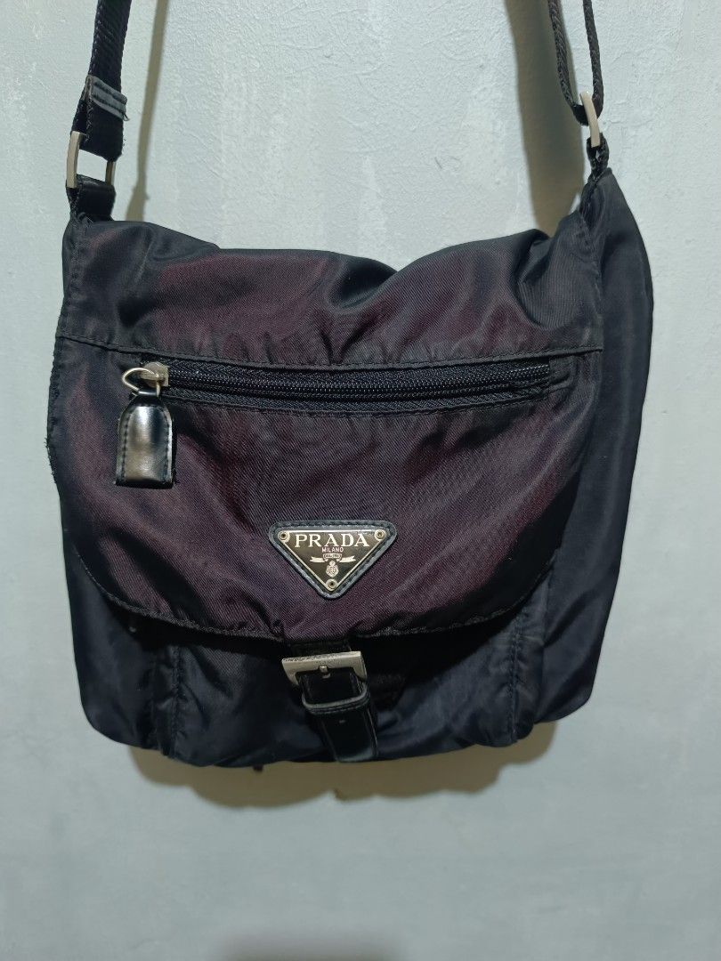 Prada Black Nylon Crossbody Messenger Bag (Category: Luxury Bags & Wallets) located in Manila. Submitted by nothingtosay_00 (Listing ID 1470357713, Image 3). Description: - Authentic Prada black nylon crossbody bag - Iconic enamel triangle logo plaque on the front flap - Adjustable shoulder strap for custom fit - Front flap with extra zipped pocket for easy access - Signature Prada logo-patterned interior lining - Internal zip pocket and official