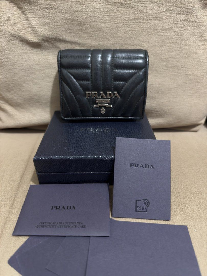 Prada Diagramme Bifold Wallet (RFID VERSION) (Category: Luxury Bags & Wallets) located in Valenzuela. Submitted by eande_manila (Listing ID 1470548076, Image 1). Description: Rank A+ In excellent condition No flaws, only minimal creasing on the inside Comes with box, card, rfid and LegitGrails 100% authentic.