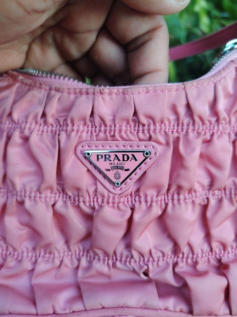 Prada Pink Ruched Nylon Shoulder Bag (Category: Luxury Bags & Wallets) located in Roxas City. Submitted by bawalthrift (Listing ID 1470431335, Image 3). Description: - Prada ruched nylon shoulder bag in a stunning pink shade - Silver-tone hardware and durable pink Saffiano leather strap - Secure top zip closure with branded metal zipper pull - Luxurious purple jacquard logo interior lining with Prada metal plaque - Features the iconic pink enamel