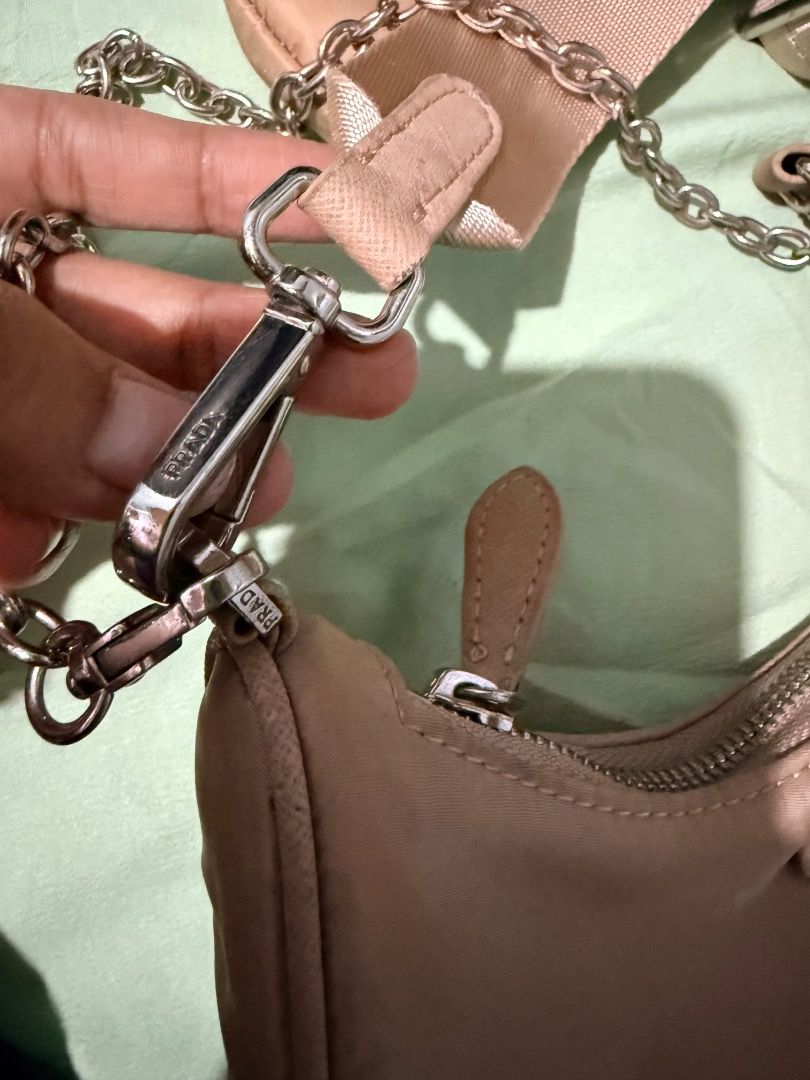 Prada Re-Edition 2005 Nylon Shoulder Bag Beige (Category: Luxury Bags & Wallets) located in Manila. Submitted by _outofthecloset. (Listing ID 1470394612, Image 2). Description: - Authentic Prada beige nylon shoulder bag - Includes adjustable webbed strap & silver-tone chain handle - Comes with a trendy detachable small pouch - Features iconic triangular enamel logo on the front - Secure top zip closure with Prada-stamped hardware - Interior lined