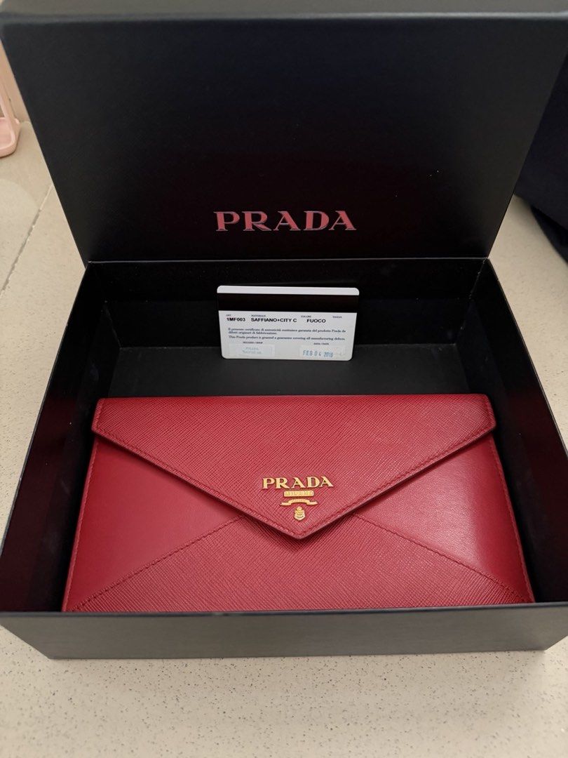 Prada Saffiano City C Fuoco Envelope Wallet with Box (Category: Luxury Bags & Wallets) located in Makati City. Submitted by blushvanilla (Listing ID 1470358646, Image 1). Description: - Brand: Prada - Style: Envelope wallet - Material: Saffiano and City leather - Color: Bright red with gold-tone hardware - Features: Snap button closure, front logo lettering, interior gold foil stamp branding - Inclusions: Original authenticity card (dated Feb 4, 