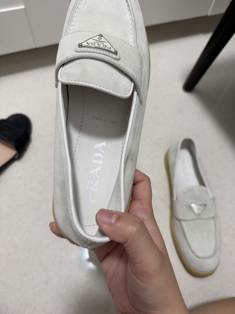 Prada Suede Loafers White Size 38 (Category: Loafers) located in Cavite. Submitted by villary (Listing ID 1470413248, Image 3). Description: - Brand: Prada 100% legit - Item: Suede Loafers - Color: White - Size: 38 (marked on inner side) - Material: Premium suede with gum rubber soles - Features: Iconic metal triangle logo plaque on front strap, embossed Prada lettering on back heel - Origin: Made in Italy - Condition: Clean overall with minimal 