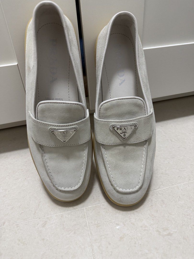 Prada Suede Loafers White Size 38 (Category: Loafers) located in Cavite. Submitted by villary (Listing ID 1470413248, Image 2). Description: - Brand: Prada 100% legit - Item: Suede Loafers - Color: White - Size: 38 (marked on inner side) - Material: Premium suede with gum rubber soles - Features: Iconic metal triangle logo plaque on front strap, embossed Prada lettering on back heel - Origin: Made in Italy - Condition: Clean overall with minimal 