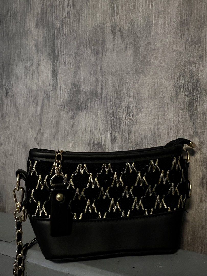 Preloved bags (Category: Cross-body Bags) located in Calamba. Submitted by saiphsavion (Listing ID 1470455448, Image 3). Description: Black Charles & Keith shoulder bag. Structured silhouette with gold-tone hardware. Thick chain straps threaded with black material wrap around the sides. Flap closure on the front with gold lettering branding. Smooth faux leather material. Compact size for daily essentials, evening out, or casual errands..