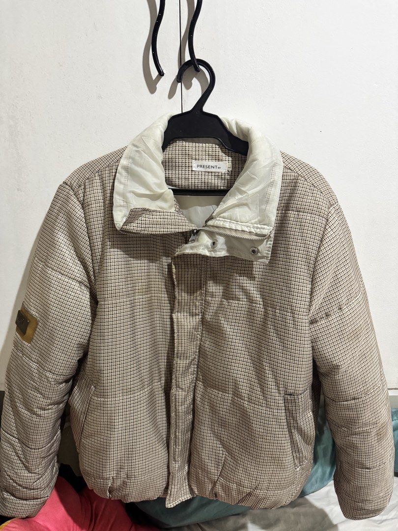 present.by Houndstooth Puffer Jacket Winter Coat (Category: Coats, Jackets and Outerwear) located in Dasmarinas. Submitted by ohfelicityshiz (Listing ID 1470469285, Image 3). Description: - Brand/Model: PRESENT.BY Puffer Jacket - Pattern: Classic beige and black houndstooth check - Features: High collar, full zip closure with snap button flap, elastic hem - Details: Decorative leather patch on the right arm and white inner collar lining - Conditi