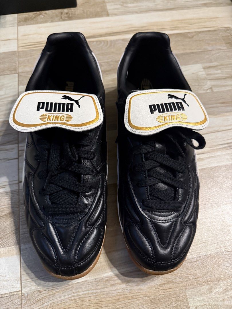 Puma King Indoor US 11 (Category: Sneakers) located in Manila. Submitted by safeowl.b6dbb0 (Listing ID 1470548831, Image 1). Description: - Brand/Model: Puma King Indoor Soccer Shoes - Colorway: Black and white with gold accents - Size: US 11.5 / UK 10.5 / EUR 45 / CM 29.5 - Material: Premium leather upper with quilted toe box stitching - Sole: Non-marking gum rubber outsole with great indoor traction - Key Feature: Iconic classic fold-over tongu
