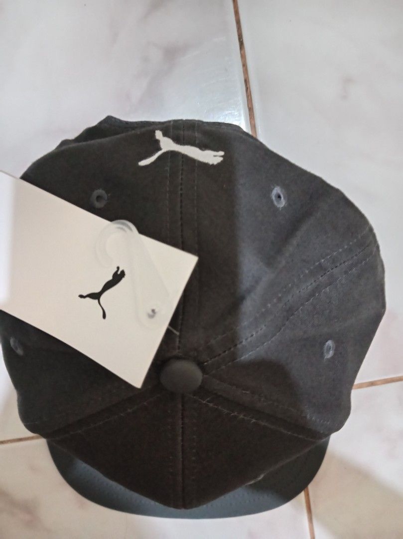 Puma Snapback Cap Dark Grey White Logo (Category: Caps & Hats) located in Las Pinas. Submitted by edpalma09136721 (Listing ID 1470514050, Image 3). Description: - Brand new with original store tags attached - Color: Dark grey with white embroidered Puma logo - Style: Flat brim snapback with holographic sticker - Fit: Adjustable strap at the back for a custom fit.