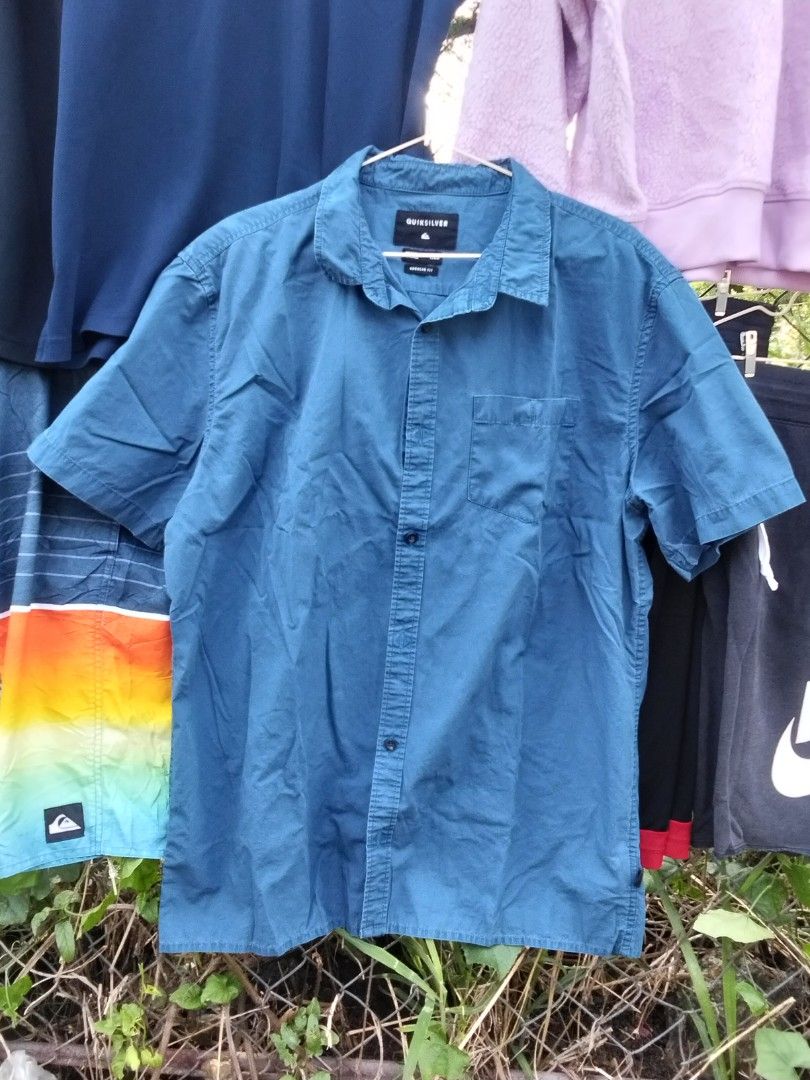 Quiksilver Blue Short Sleeve Button-Down Shirt (Category: Tshirts & Polo Shirts ) located in Quezon City. Submitted by kemjhon (Listing ID 1470447197, Image 1). Description: - Brand: Quiksilver - Style: Short sleeve button-down shirt with collar and front button closure - Colour: Teal blue (solid) - Size: Large (180/96A measurements) - Material: Comfortable 100% cotton - Fit: Regular fit with a convenient chest pocket - Condition/Use: Classic cas