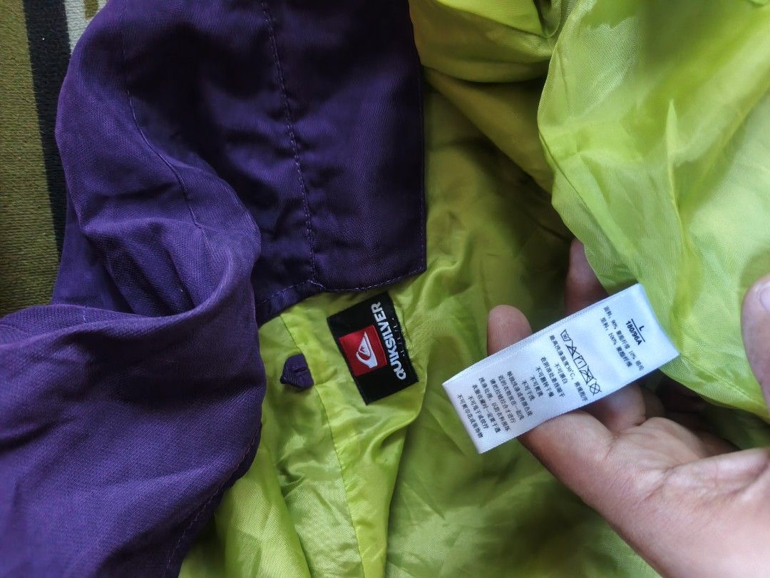 Quiksilver Purple Jacket Neon Green Lining Size L (Category: Coats, Jackets and Outerwear) located in Bayombong. Submitted by onlygoodfinds. (Listing ID 1470389870, Image 3). Description: - Brand: Quiksilver - Style: Zip-up hooded jacket / Streetwear outerwear - Color: Deep purple with bright neon green inner lining and zipper - Size: L (180/96A on tag) - Features: Multiple front pockets with snap buttons, adjustable drawstring hood - Condition: 